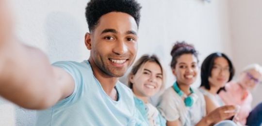 Foto com vários jovens sentados lado a lado